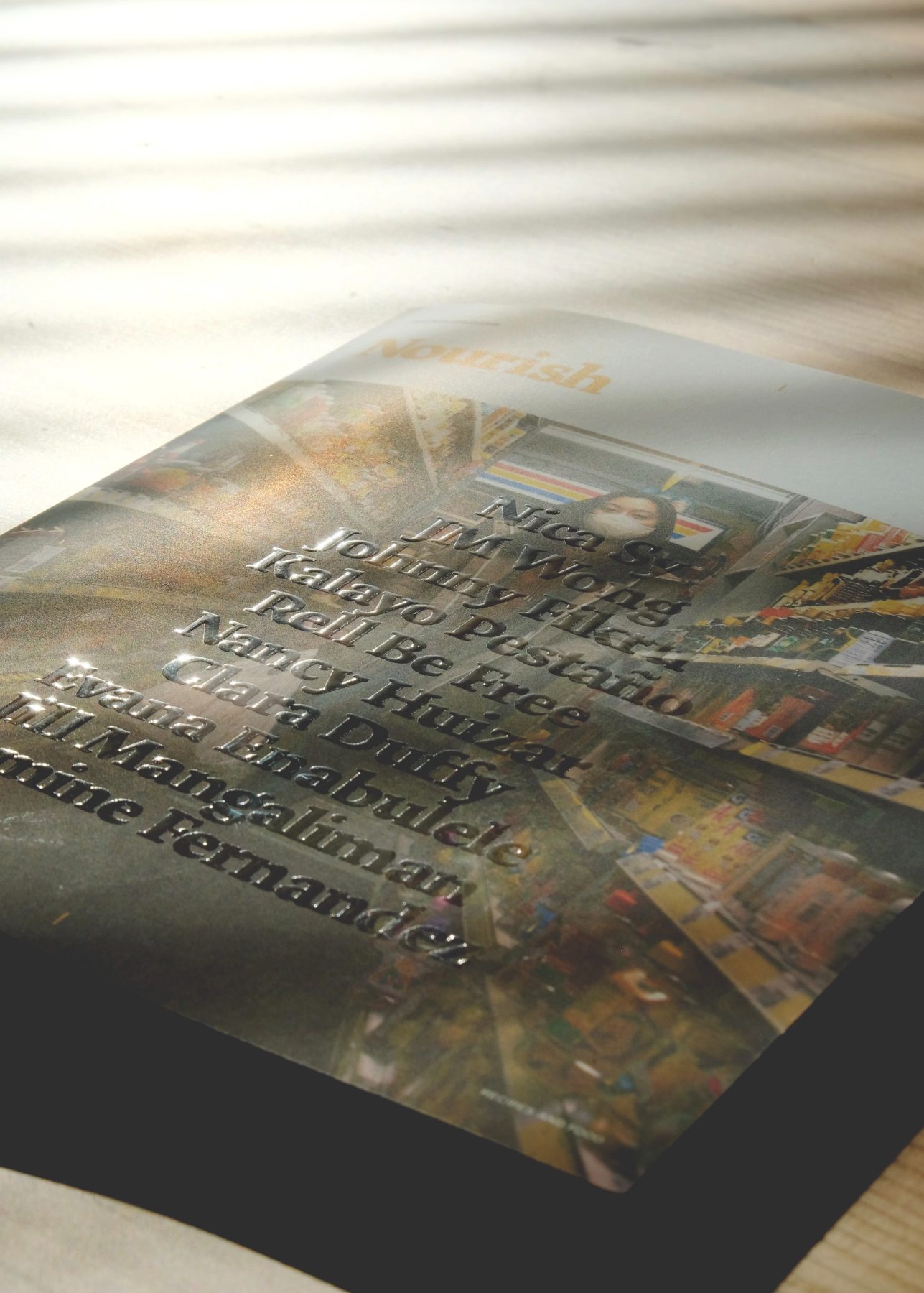 Nourish book cover with foil-stamped contributor names